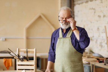 ciddi yaslilar üzerinde gözlük atölyesinde çalışırken koyarak