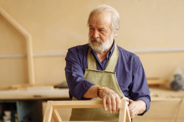 Eski yakışıklı woodworker tamircisi ciddi konum ile ayakta
