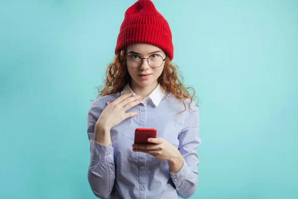 Jengibre adolescente con gorra roja y camisa azul mirando a la cámara — Foto de Stock