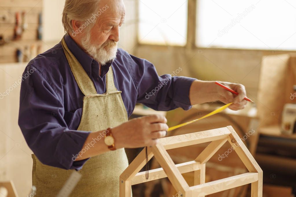 close-up portrait of old artisan wearing apron and