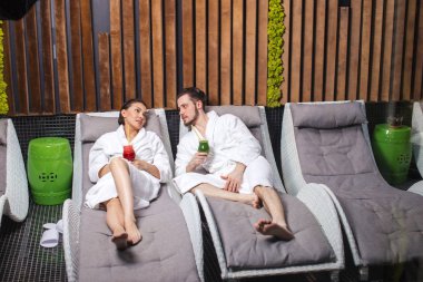 Tıraşsız yakışıklı ve güzel kadın güzellik merkezi şezlong üzerinde siyah saç supening ile