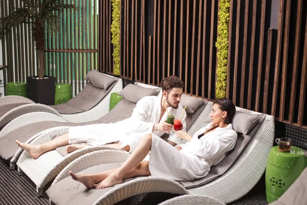 Encontro romântico incomum. muito masculino e feminino estão bebendo suco após sauna — Fotografia de Stock