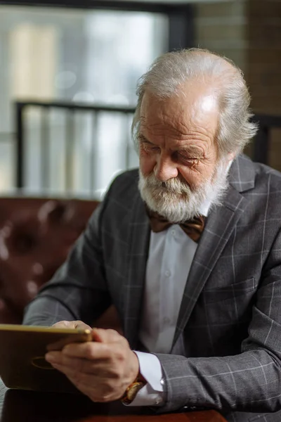 正式服装退休男子特写肖像在平板电脑上玩游戏 — 图库照片