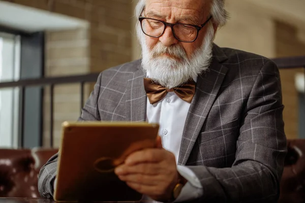 Пенсионер с седыми волосами и бородой все знают о гаджетах — стоковое фото