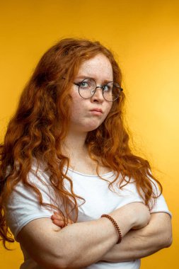 Yüzünde negatif insan ifadesi olan kızıl saçlı kadın..