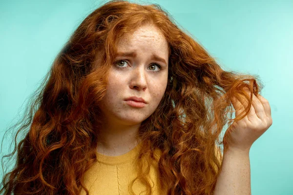 Perturbado e mulher com sua expressão de rosto cabelo seco danificado fundo azul — Fotografia de Stock