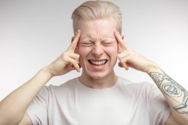 Bitcoin fiyatlarındaki ani düşüşten bıkmış, parmaklarını şakaklarda tutan adam.