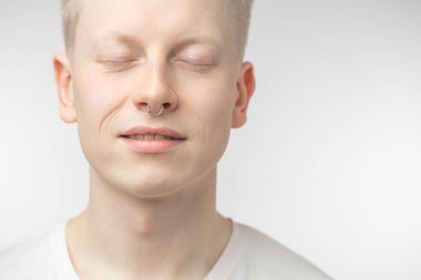 Beyaz arka plan üzerinde matkap tutan gülümseyen yakışıklı genç bir adam portresi