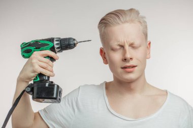 Bir tapınak sondaj adam. Migren, baş ağrısı ve mazoşizm kavramı. Stüdyo vurdu. Grenli gri arka plan.