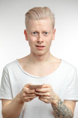 Suratı asık sinirli bir erkek cep telefonundan nahoş haberler alıyor..