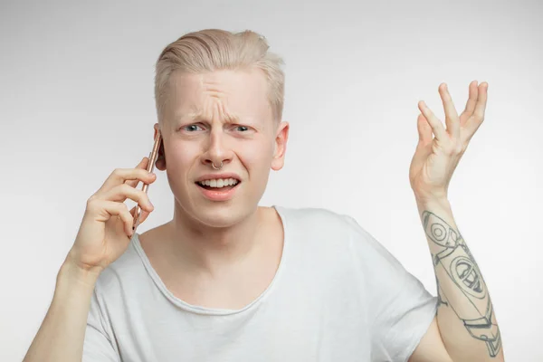 Homem irritado com rosto franzido recebendo notícias desagradáveis no telefone celular. — Fotografia de Stock