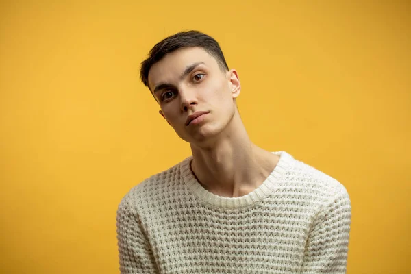 Портрет умного серьезного молодого человека, стоящего на жёлтом фоне — стоковое фото