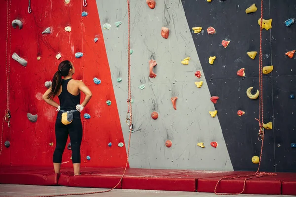 Esportista olhando para a parede de escalada no ginásio — Fotografia de Stock