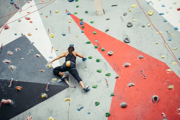 Güzel genç bir kadın yapay bir duvara doğru büyük bir adım atıyor.