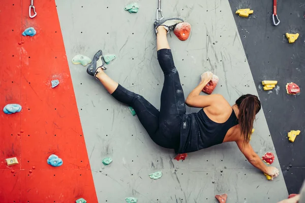 Güzel genç bir kadın yapay bir duvara doğru büyük bir adım atıyor.