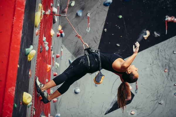 Mulher feliz ativo pendurado na corda bamba no centro de escalada de treinamento — Fotografia de Stock