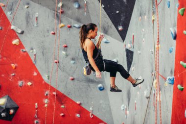 Güzel genç bir kadın yapay bir duvara doğru büyük bir adım atıyor.