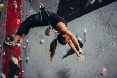 Antrenman merkezinde ipte asılı duran mutlu aktif bir kadın.