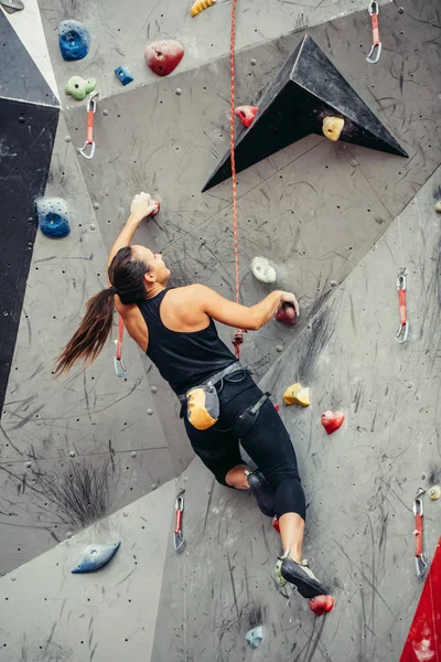Sportovní žena v balvanu horolezecká hala — Stock fotografie