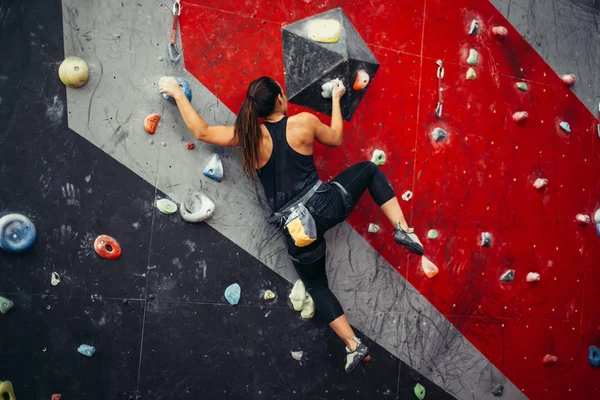 Hermosa joven mujer dando un gran paso por una pared artificial —  Fotos de Stock