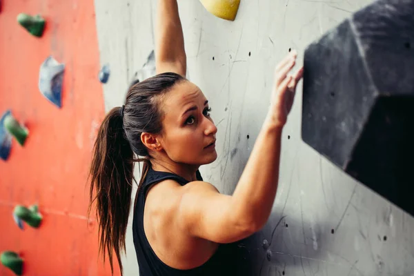 Hermosa joven fuerte mujer escalada en rojo artificial vista superior de la pared. — Foto de Stock