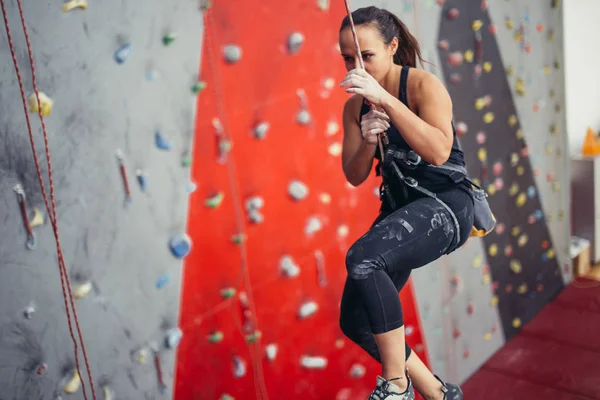 Mujer feliz activa sobresaliendo en la cuerda floja en el centro de escalada de entrenamiento — Foto de Stock
