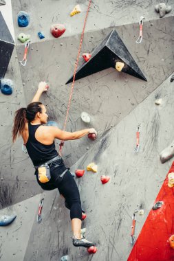 Kaya tırmanış salonundaki sporcu kadın.
