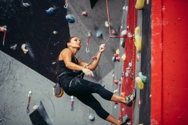 Antrenman merkezinde ipte asılı duran mutlu aktif bir kadın.