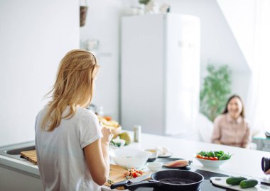 Genç ev hanımı mutfakta Linch 'e yemek yapıyor. arka plan