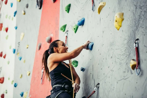 Belle jeune femme faisant un grand pas vers le haut d'un mur artificiel — Photo