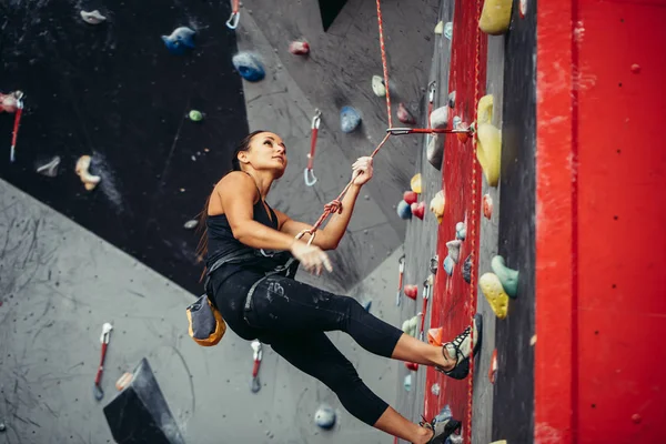 Mujer feliz activa sobresaliendo en la cuerda floja en el centro de escalada de entrenamiento — Foto de Stock