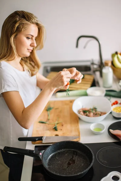 Mujer haciendo kebabs de carne y verdura en la tabla de cortar en la cocina — Foto de Stock