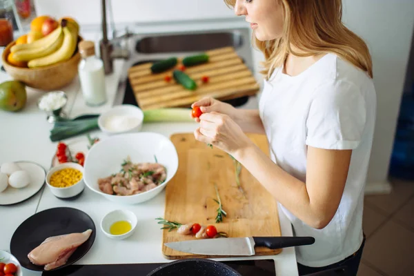 Mujer haciendo kebabs de carne y verdura en la tabla de cortar en la cocina — Foto de Stock