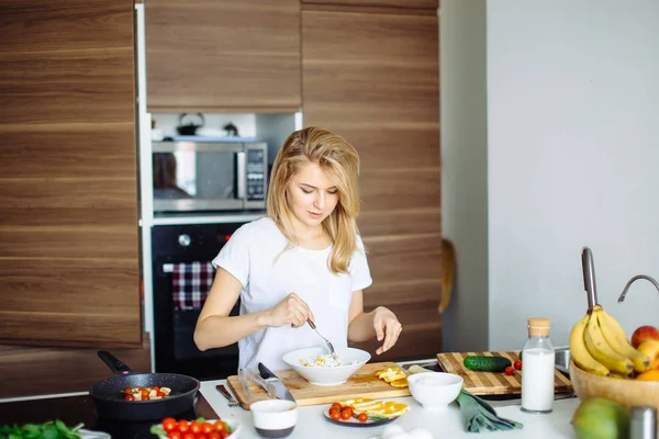 Femme mélangeant de délicieux ingrédients de salade superfood avec des cuillères en bois dans la cuisine — Photo