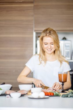 Genç bayan aşçı mutfakta yemek pişiriyor.