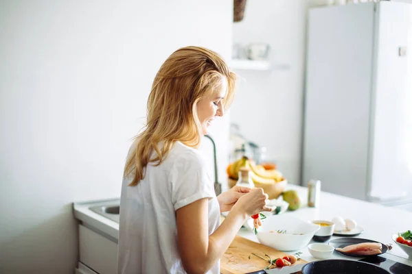 Young housewife making meal for linch in kitchen. rear view — Stock Photo, Image