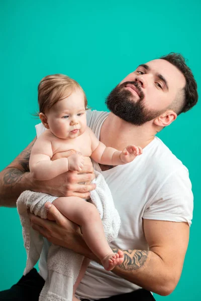 Speelse vader zijn lachende baby kind over blauwe achtergrond op de nek te dragen — Stockfoto