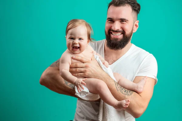 Padre juguetón llevando a su niño sonriente en el cuello sobre fondo azul — Foto de Stock