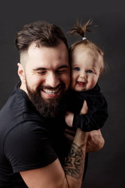 Şirin bebek siyah arka plan üzerine tutarak dövmeli yakışıklı genç