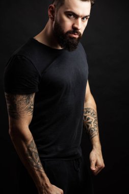 Güven ve güç. Yetişkin atletik adam siyah arka plan üzerinde ayakta