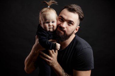 Siyah arka plan üzerine bebek ile genç atletik baba
