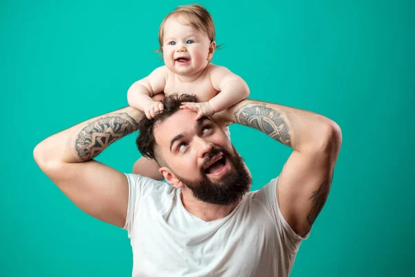 Gelukkig vader uitvoering van zijn dochtertje op nek geïsoleerd op blauwe achtergrond — Stockfoto