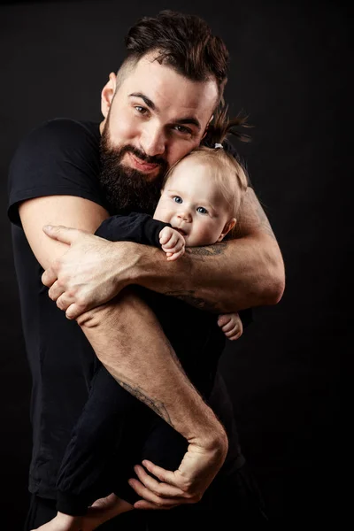 Joven padre atlético con adorable bebé sobre fondo negro —  Fotos de Stock