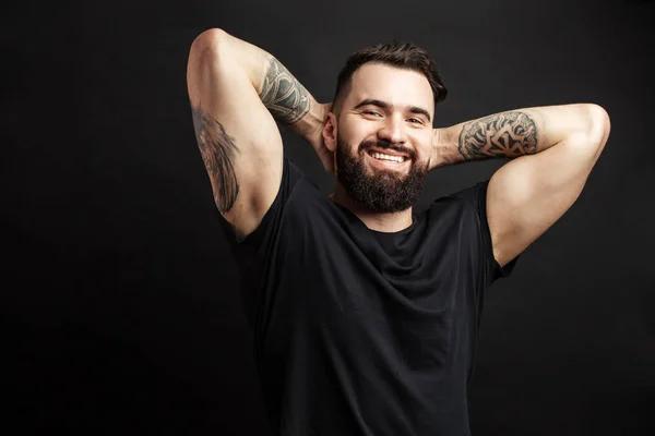 Portrait of handsome young man in casual t-shirt over black background. — Stock Photo, Image