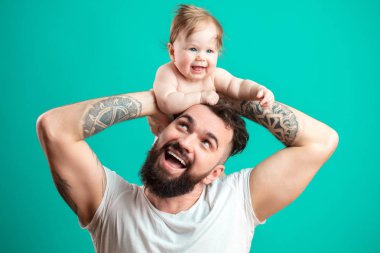 Mutlu baba bebek kızı üzerinde mavi arka plan izole boynunda taşıyan