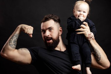 Muscular father holding his little baby clipart