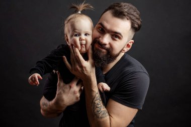 Siyah arka plan üzerine bebek ile genç atletik baba