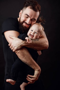 Siyah arka plan üzerinde atış stüdyo seven baban zevk, şefkat ve sevgi, onun gözünden kapanış yavaşça onun güzel bebek kız, kucaklayan izole.