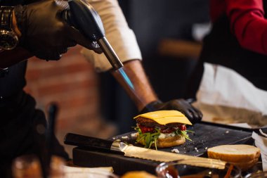Aşçı hamburgercide biftek yapıyor.