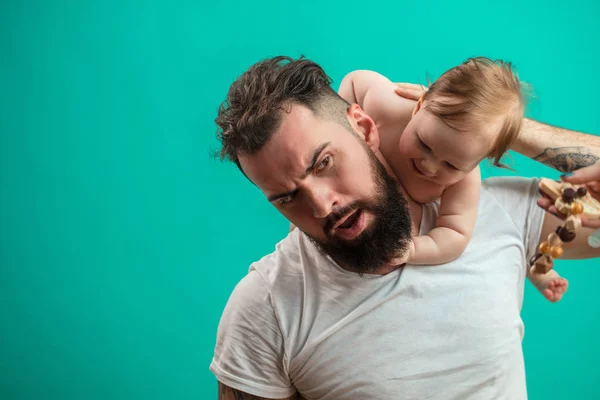 Padre juguetón llevando a su niño sonriente en el cuello sobre fondo azul —  Fotos de Stock